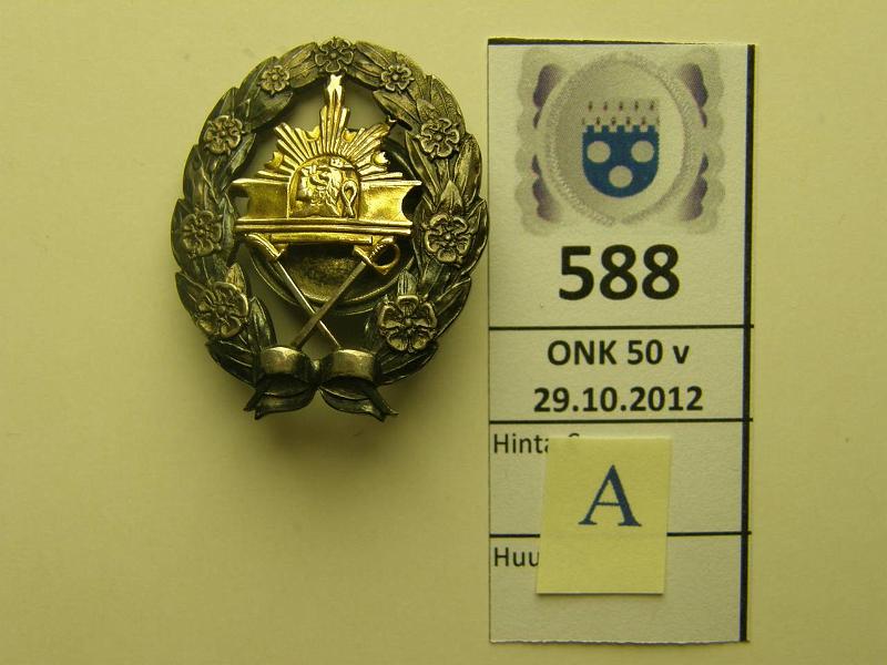 k-0588-a.jpg - Kohde 588 (kuva 1/2), lhthinta: 75 € Ag, Kadettikunnan merkki, vanha malli, miekat alas. Kntp. omistuskaiverrus EB Hellman, hopean leimat, kunto: 8